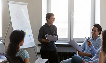 Presenter at a flip chart leading a small team discussion